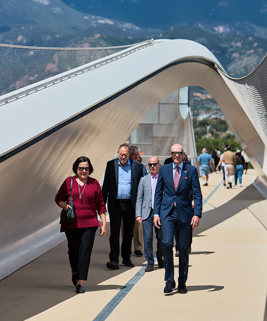 Group of people walking beneath walking bridge