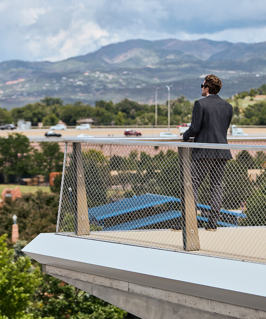 Man standing looking at scenery of walking bridge