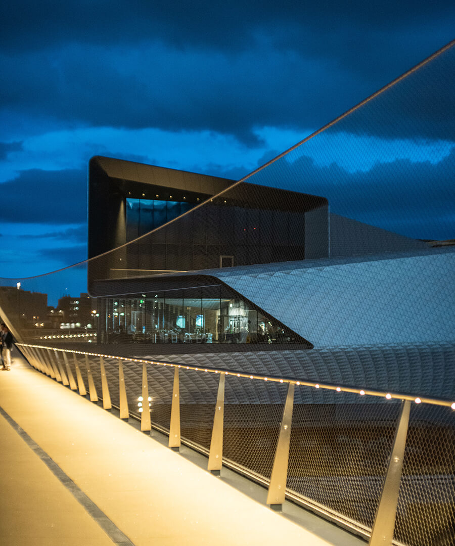 Walking bridge view overlooking indoor event space at night