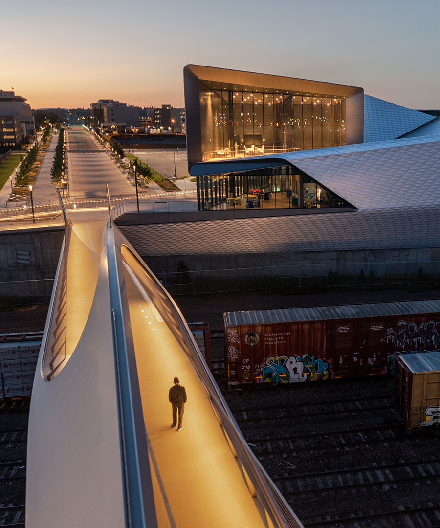 Downtown Colorado Springs walking bridge at dusk with one man walking across